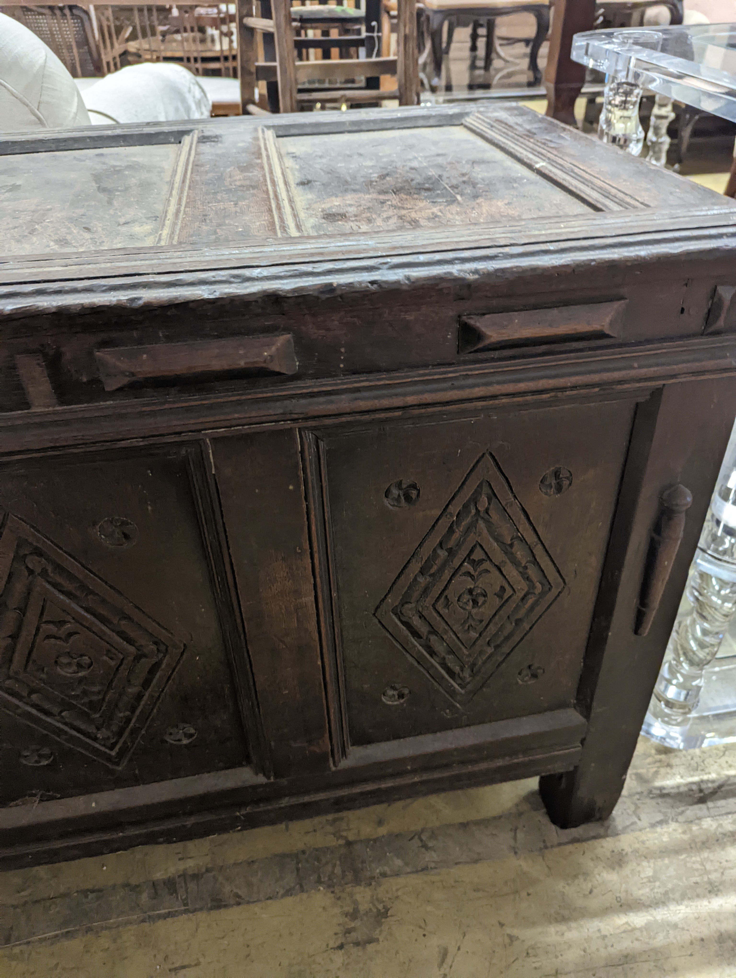 An early 18th century oak coffer, with four panel top and later carved and applied decoration, length 151cm, depth 63cm, height 76cm